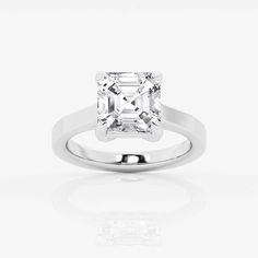 an engagement ring with a princess cut diamond in the center, on a white background