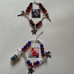 two bracelets with charms and pictures hanging from them on a white surface, one is red, the other is blue