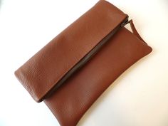 Genuine real leather brown simple everyday foldober zippered clutch bag. *Exterior High quality buttery soft supple pebbled real genuine leather. *interior - Fully lined with 100% natural cotton in chocolate brown. * Closes with YKK antique gold toned metal zipper closure. Approx. measurments (unfolded): Width -12 inches Height- 11.5 inches Simple Leather Bag, Foldover Crossbody Bag, Brown Clutch, Embroidered Handbag, Foldover Clutch, Leather Clutch Bag, Canvas Clutch, Simple Leather, Zippered Clutch