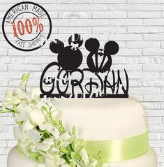 there is a wedding cake with mickey and minnie mouse topper