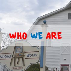 there is a sign that says who we are in front of a white building with red and blue lettering