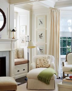 a living room filled with furniture and a fire place in front of a mirror on the wall