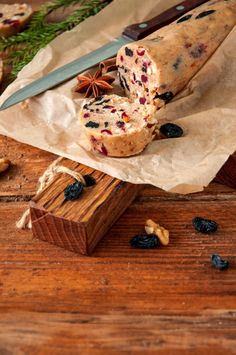 a knife and some food on top of a piece of wax paper next to nuts