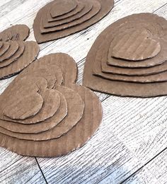 four brown paper plates sitting on top of a wooden table next to each other with circles cut out of them