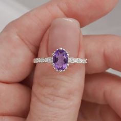 Introducing the exquisite "Juliet" Amethyst and White Topaz Ring – a timeless symbol of love and elegance. Crafted with passion and precision, this enchanting piece will captivate hearts and turn heads wherever it graces your hand. At the center of this ring lies a resplendent amethyst gemstone, deeply alluring with its regal purple hue. The amethyst, known for its association with tranquility and balance, embodies the spirit of royalty, making you feel like a true queen. Its mesmerizing violet tones dance gracefully in the light, commanding attention from all angles. Surrounding the amethyst are sparkling white topaz gemstones, meticulously set to accentuate the brilliance of the center stone. The white topaz, akin to little stars twinkling in the night sky, complements the amethyst's all Timeless Symbol, White Topaz Rings, Purple Hues, Topaz Gemstone, Moon Child, Love Symbols, Topaz Ring, Amethyst Gemstone, White Topaz