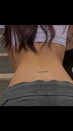 the back of a woman's stomach with an inscription on her left side that reads straight