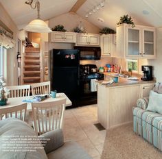 a kitchen and living room are shown in this image with the stairs leading up to the second floor