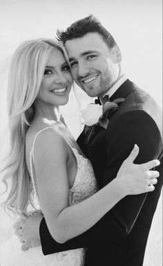 the bride and groom are posing for a black and white photo in their wedding attire