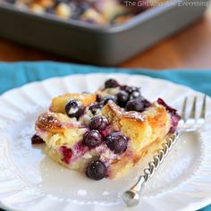 a white plate topped with blueberry cobbler next to a fork