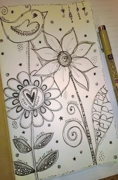 a drawing on paper with flowers and stars in the background, next to a pen