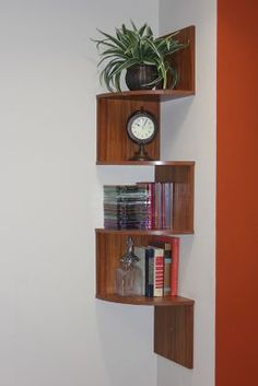 three wooden shelves holding books and a clock