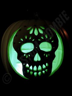 an illuminated pumpkin with a skull on it