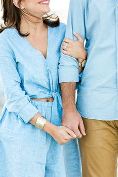 a man and woman standing next to each other with their arms around each other smiling