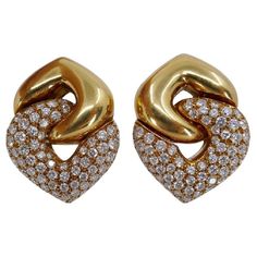 A pair of the classic Bulgari Doppio Cuore earrings in yellow gold, featuring diamonds. The earrings are designed as two interlocked hearts: a gold reversed heart holds a diamond one. This pair is the largest in the wide range of the collection's sizes. The heart design is one of the widely using element in Bulgari jewelry making. It reflects the brand's ability to infuse romance and passion into a piece. Bulgari's heart design is not only visually captivating but also emotionally resonant. Whet Bulgari Earring, Bulgari Jewelry, Heart Themed, Gold Diamond Earrings, Themed Jewelry, Diamond Stone, Heart Design, Heart Shape, Jewelry Art