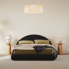 a large bed sitting next to two lamps on either side of the headboard and foot board