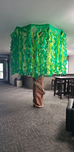 there is a tree made out of tissue paper in the middle of an office lobby