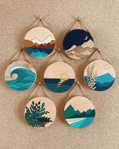 six handmade wooden wall hangings with different designs on them, each featuring an ocean scene