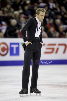 a man in a tuxedo standing on an ice rink with his hands on his hips