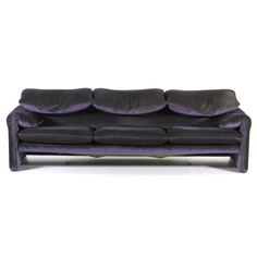 a black and purple couch sitting on top of a white floor