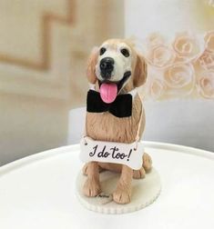 a dog figurine sitting on top of a table with a sign that says i do too