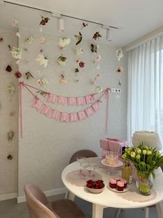 a white table topped with cake and flowers