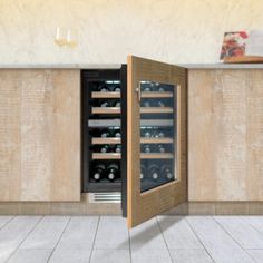 an open wine cooler sitting in the middle of a kitchen with white tile flooring