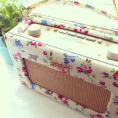 an old fashioned radio sitting on top of a table next to a potted plant