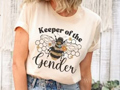 a woman wearing a t - shirt that says keeper of the genderer