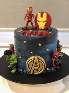 the avengers birthday cake is decorated with iron man and captain america figures