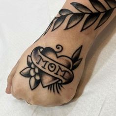 a black and white tattoo on the foot of a person with an i love mom ribbon