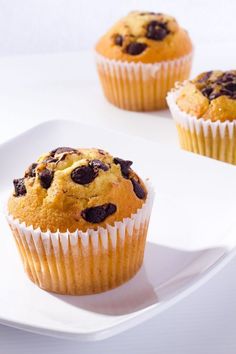 three blueberry muffins on a white plate