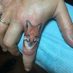 a woman's hand with a fox tattoo on it