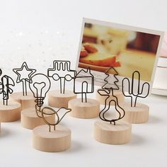 a group of wooden sculptures sitting on top of a white table next to a photo