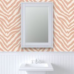 a white sink sitting under a mirror next to a wall mounted faucet in a bathroom