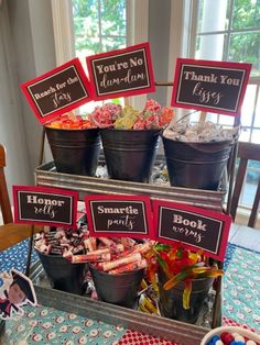 a table topped with buckets filled with candy