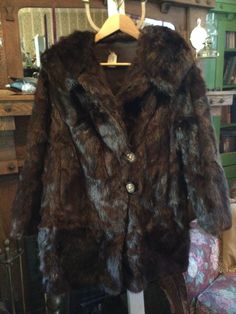 This stunning shorter coat is made of genuine beaver fur in the richest shade of espresso brown. It fastens with the original decorative buttons and elastic loops, and has two outer pockets and one inner pocket. It is fully lined with brown satiny lining imprinted with a brown and pale blue floral design. Stunning inside and out! The measurements, taken with the coat lying flat, are: shoulder to shoulder, 20 inches; armpit to armpit; 21 inches; sleeves, 20 inches; length, 35 inches; bottom edge; 26 inches. In excellent condition. Luxury Brown Mohair Outerwear, Grunge Fairycore Coats & Jackets, Luxury Brown Fur Coat With Pockets, Luxury Brown Fur Coat With Fleece Lining, Goth Outfits Men, Beaver Fur Coat, Brown Fur Coat, Fashion Figure Drawing, Club Fits