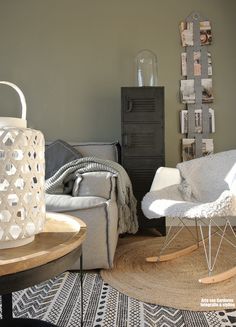 a living room filled with furniture next to a tall wooden table and white chair on top of a rug