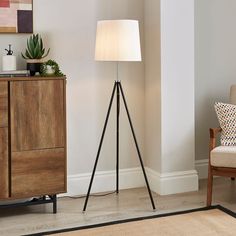 a living room scene with focus on the tripod floor lamp next to the chair