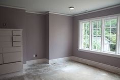 an empty room with no furniture in it and the walls are painted purple, while the floor is white