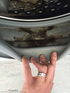 a person is holding their hand up to the side of a car with rust on it