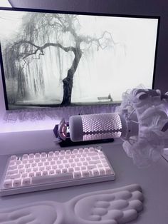 a computer keyboard sitting on top of a white desk next to a mouse and monitor