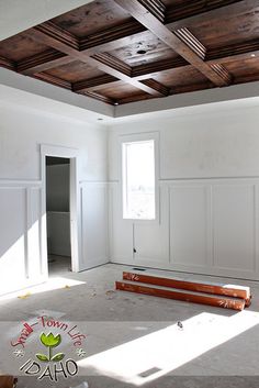 an empty room with white walls and wood paneling on the ceiling is being remodeled