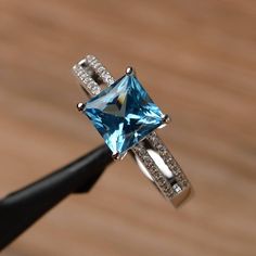 It is a Swiss blue topaz ring. The main stone is 7mm*7mm square cut, weight about 2.31carats. The basic metal is sterling silver and plated with rhodium. To change the metal to a solid gold (white/rose) or platinum is also available, please ask for a quotation if you want. You can also go to my shop Home for more elegant rings: https://www.etsy.com/shop/godjewelry?ref=hdr_shop_menu More rings: https://www.etsy.com/shop/godjewelry?ref=l2-shop-header-avatar Customization is always welcome and plea Blue Topaz Promise Ring, Blue Topaz Ring Sterling Silver, Topaz Wedding Ring, Elegant Rings, Black Spinel Ring, Pink Morganite Engagement Ring, November Birthstone Ring, Swiss Blue Topaz Ring, Topaz Birthstone