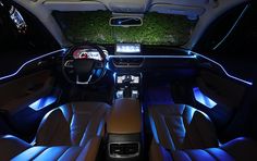 the interior of a car with blue lights and leather seats, including an entertainment center