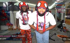 two young men wearing spiderman costumes in a room