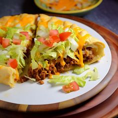 a plate with some taco salad on it and one slice is cut in half