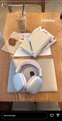 an apple laptop computer sitting on top of a wooden table next to headphones and a notebook