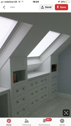 an attic bedroom with white cabinets and skylights