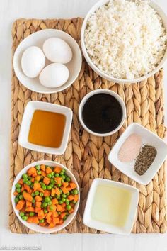 ingredients to make rice and carrots laid out in bowls on a woven place mat