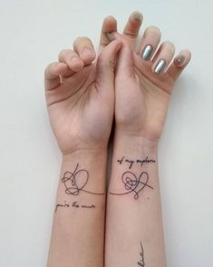 two wrist tattoos with words on them